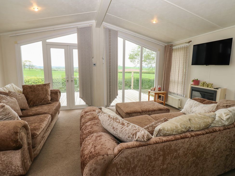 A living room with sliding doors and sofa at Plot 34 in Carlisle