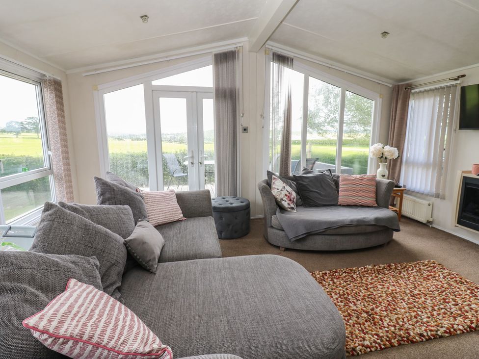 A living room with sofas and a door to the outside at Plot 34 near Armathwaite