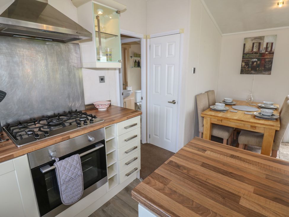 A kitchen with a stove and dining table at Plot 34 near Armathwaite