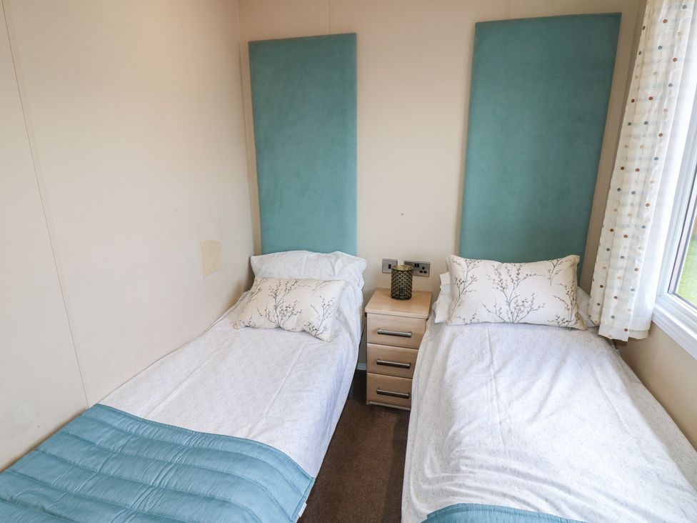 A bedroom with two beds and a nightstand at Plot 34 near Armathwaite