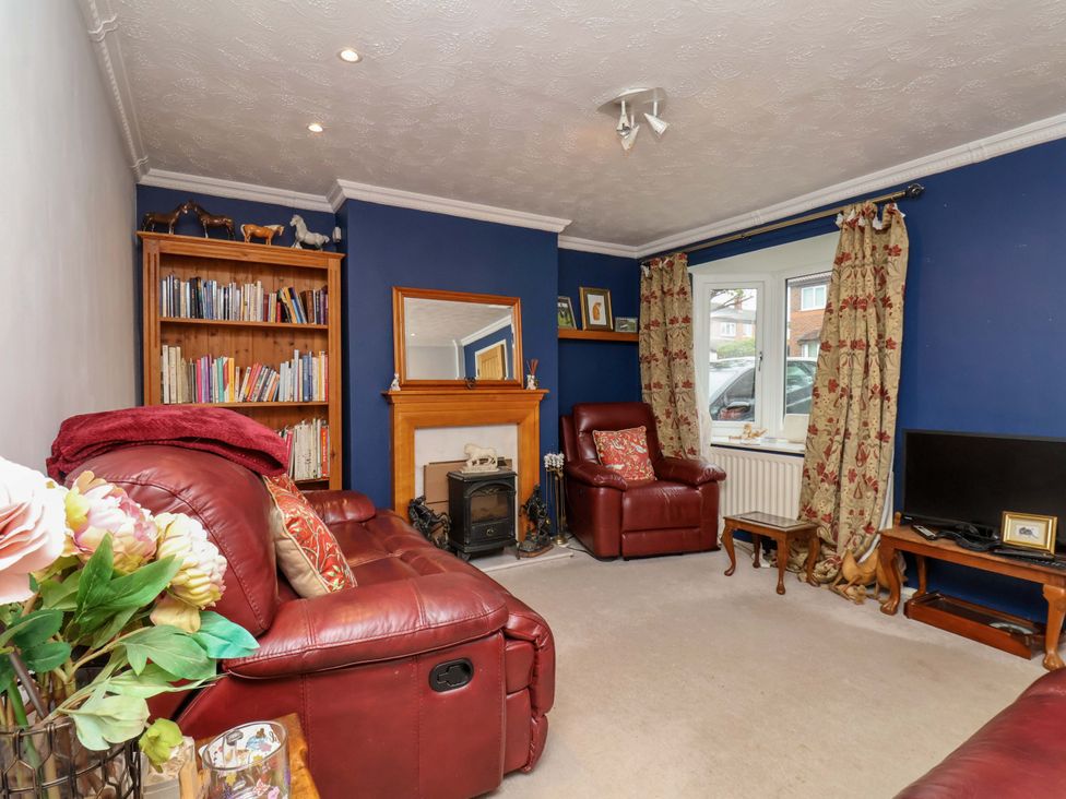 A living room with a sofa and bookshelf at 7 Crestbrooke in Northallerton