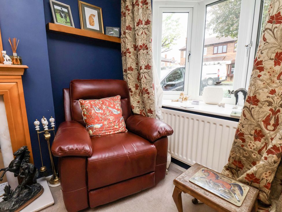 A living room with an armchair and shelf at 7 Crestbrooke in Northallerton