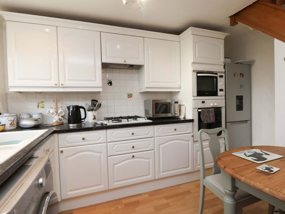 A kitchen with cabinets, sink, stove, and dining table at 7 Crestbrooke Northallerton