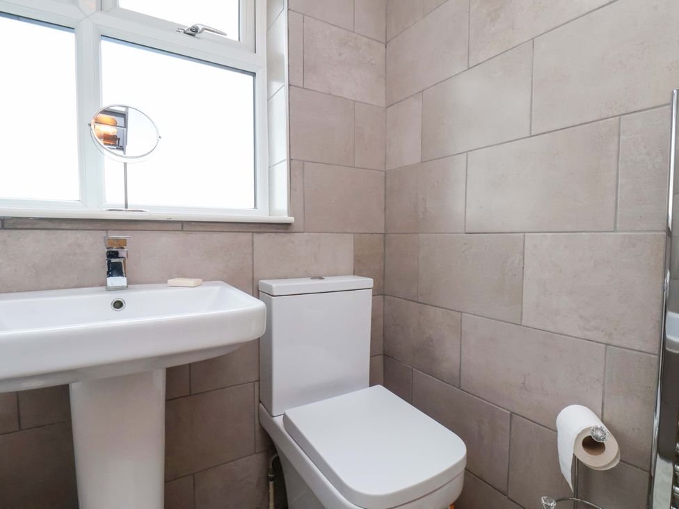 A bathroom with a sink, toilet, and window at 7 Crestbrooke Northallerton