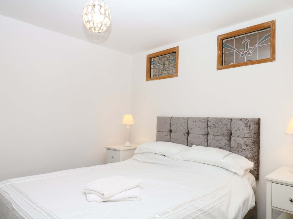 A bedroom with a bed and nightstand at The Headmasters Quarters in Chudleigh