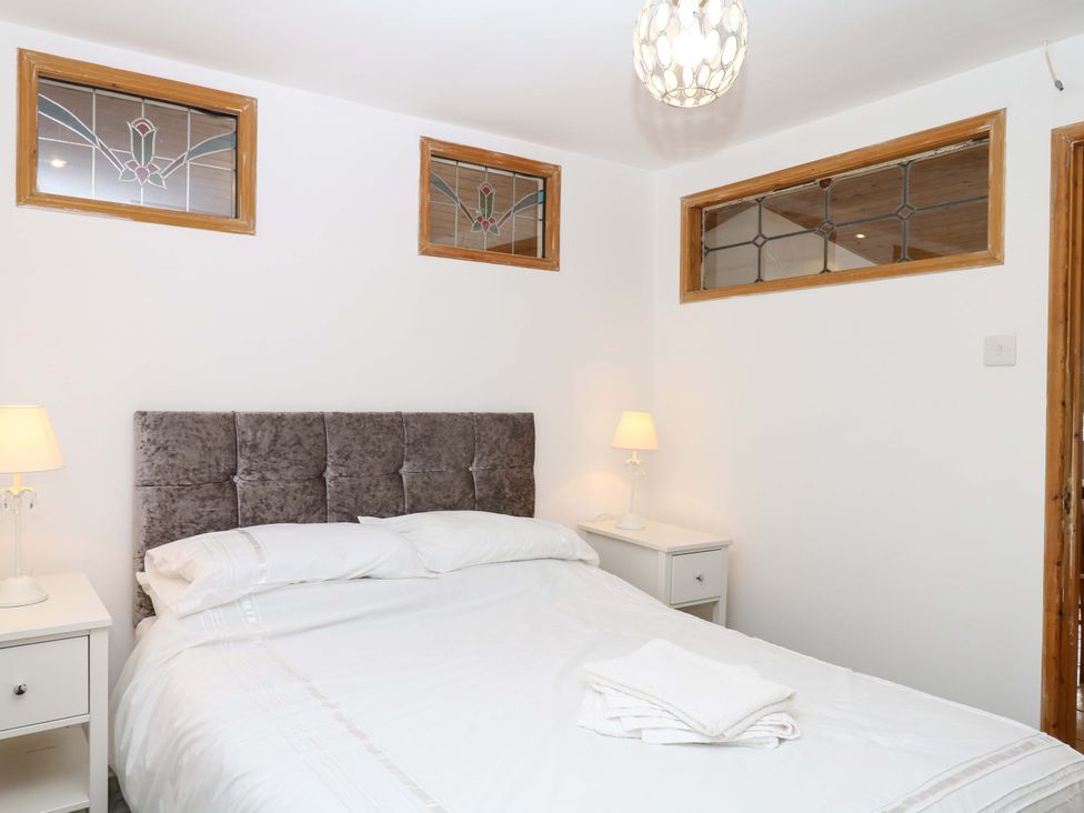 A bedroom with a bed and bedside lamp at The Headmasters Quarters in Chudleigh