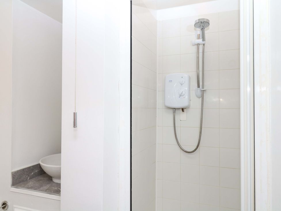 A shower with a showerhead and control unit in a bathroom at The Headmasters Quarters Chudleigh