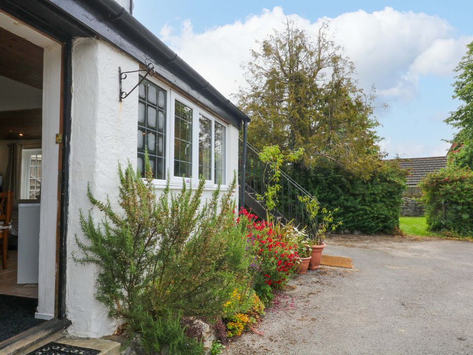 An entrance with window, door, and flowers at The Headmasters Quarters in Chudleigh
