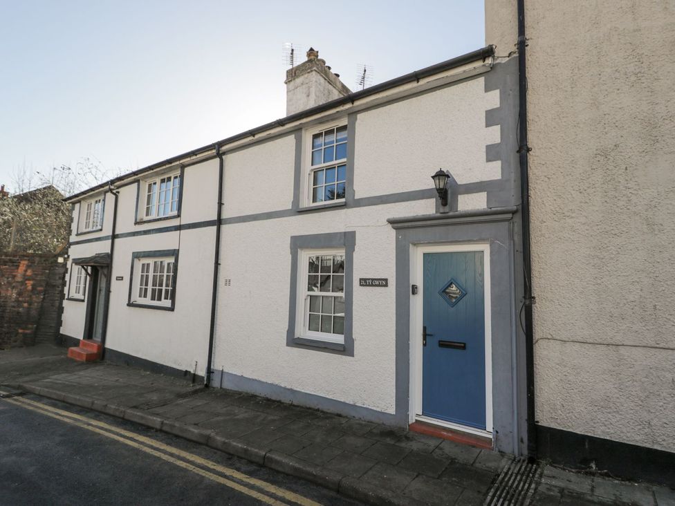 A house exterior with a blue door and windows at Ty Gwyn in Aberdovey