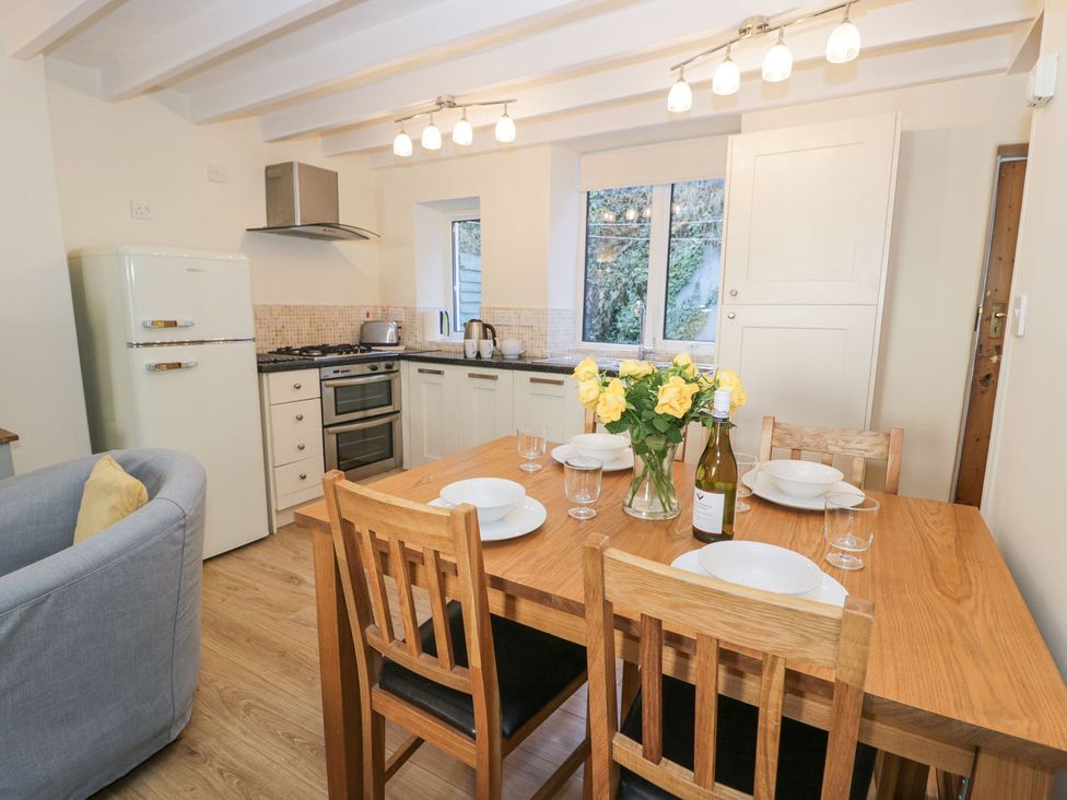 A kitchen with dining table and appliances at Ty Gwyn in Aberdovey