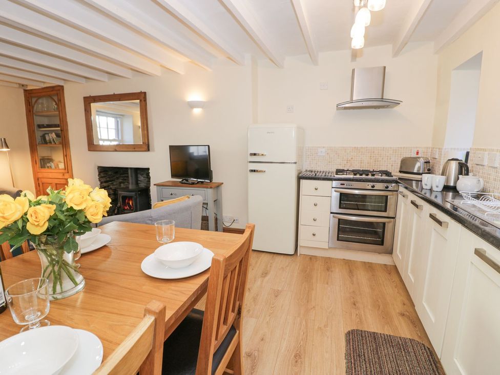 A kitchen with dining area and appliances at Ty Gwyn in Aberdovey