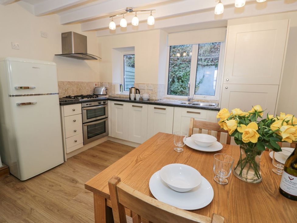 A kitchen with a table and chairs at Ty Gwyn in Aberdovey