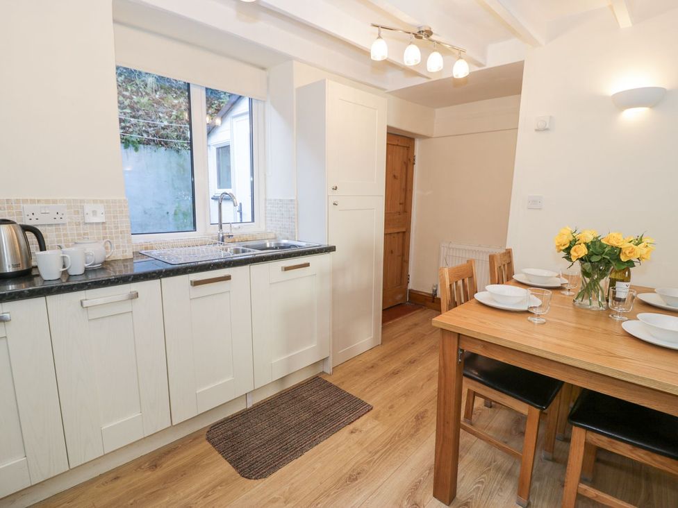 A kitchen with a table and chairs at Ty Gwyn in Aberdovey