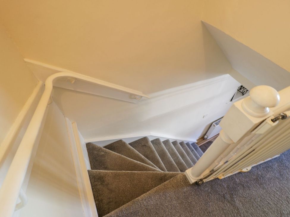 A staircase with carpet and handrail at Ty Gwyn in Aberdovey