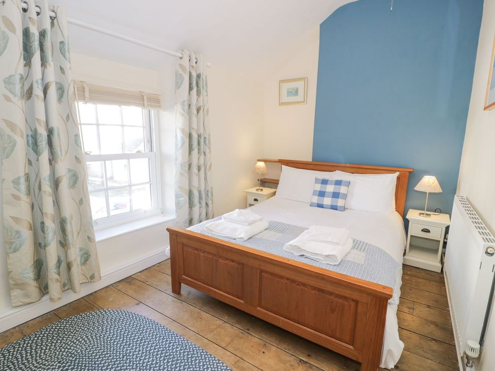 A bedroom with a bed and nightstands at Ty Gwyn in Aberdovey