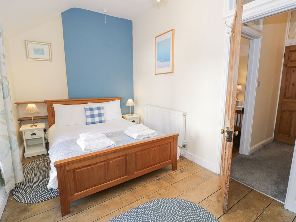 A bedroom with a bed and nightstands at Ty Gwyn in Aberdovey