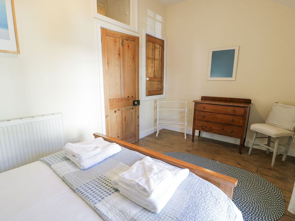 A bedroom with a bed and towels on top at Ty Gwyn in Aberdovey