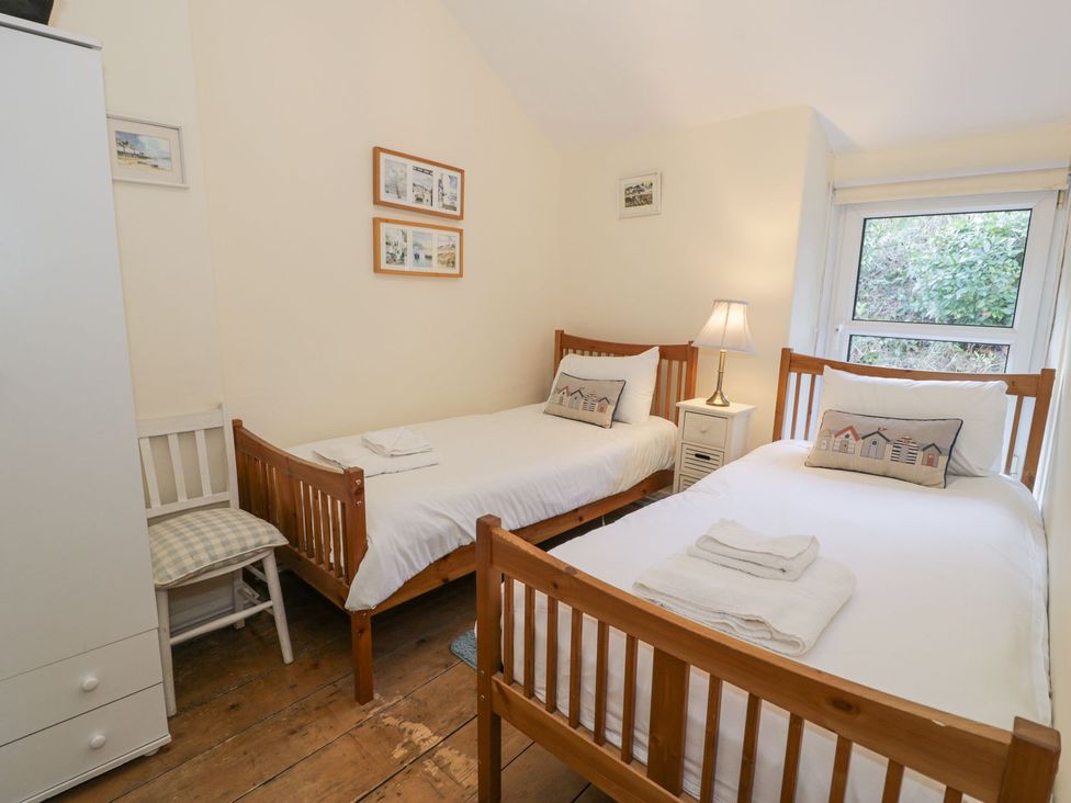 A bedroom with two beds and a nightstand at Ty Gwyn in Aberdovey