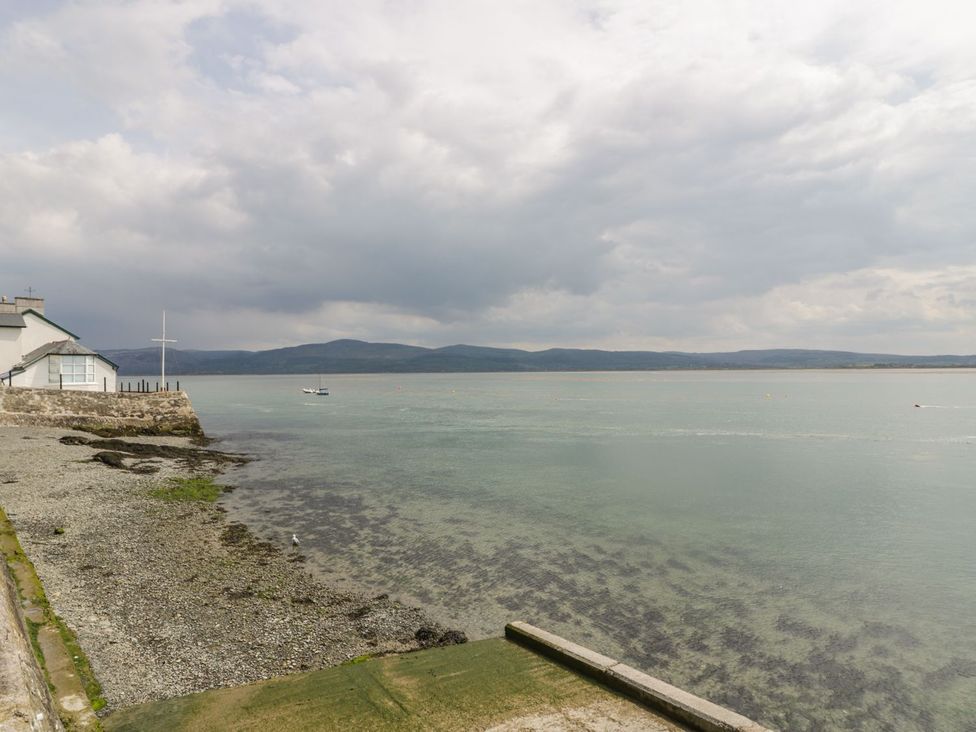 A view of water with a building and a boat at Ty Gwyn in Aberdovey