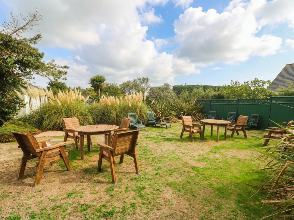 A garden with wooden furniture and plants at 8 Yellow Sands in Padstow