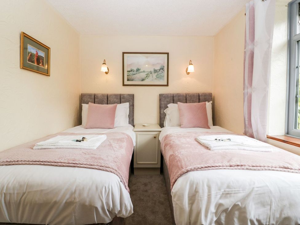 A bedroom with two single beds and art on the walls at Oak Tree in Weston-super-Mare