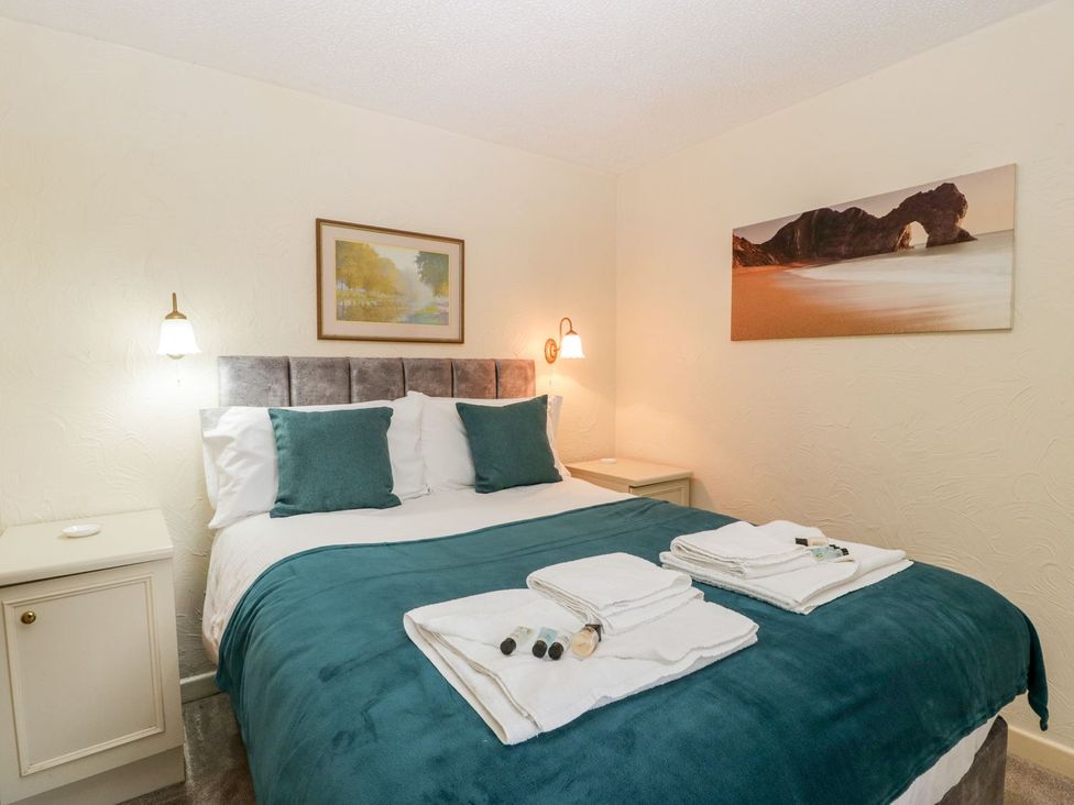 A bedroom with a bed and bedside table at Oak Tree in Weston-super-Mare