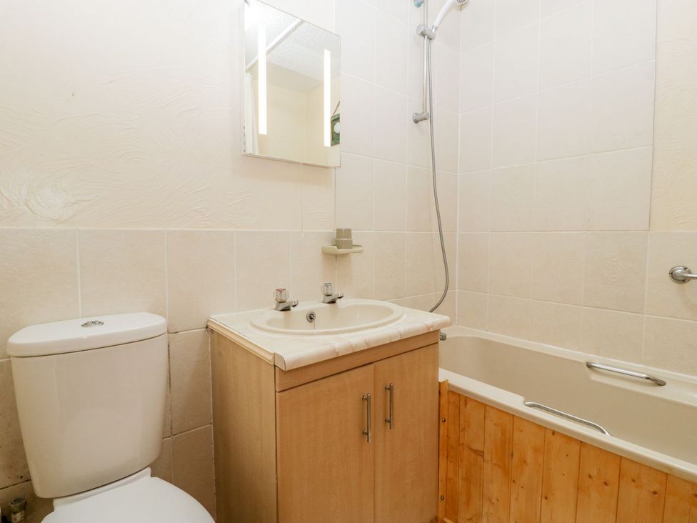 A bathroom with a sink, toilet, bathtub, and shower at Oak Tree in Weston-super-Mare