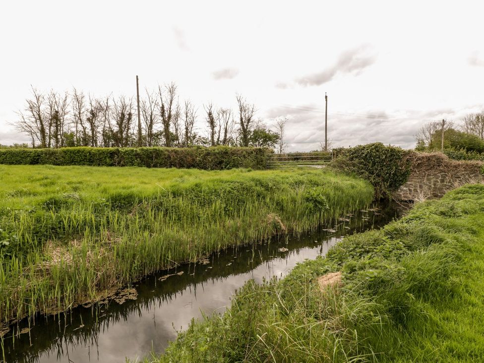 A view of a stream surrounded by grass and trees at Oak Tree in Weston-super-Mare