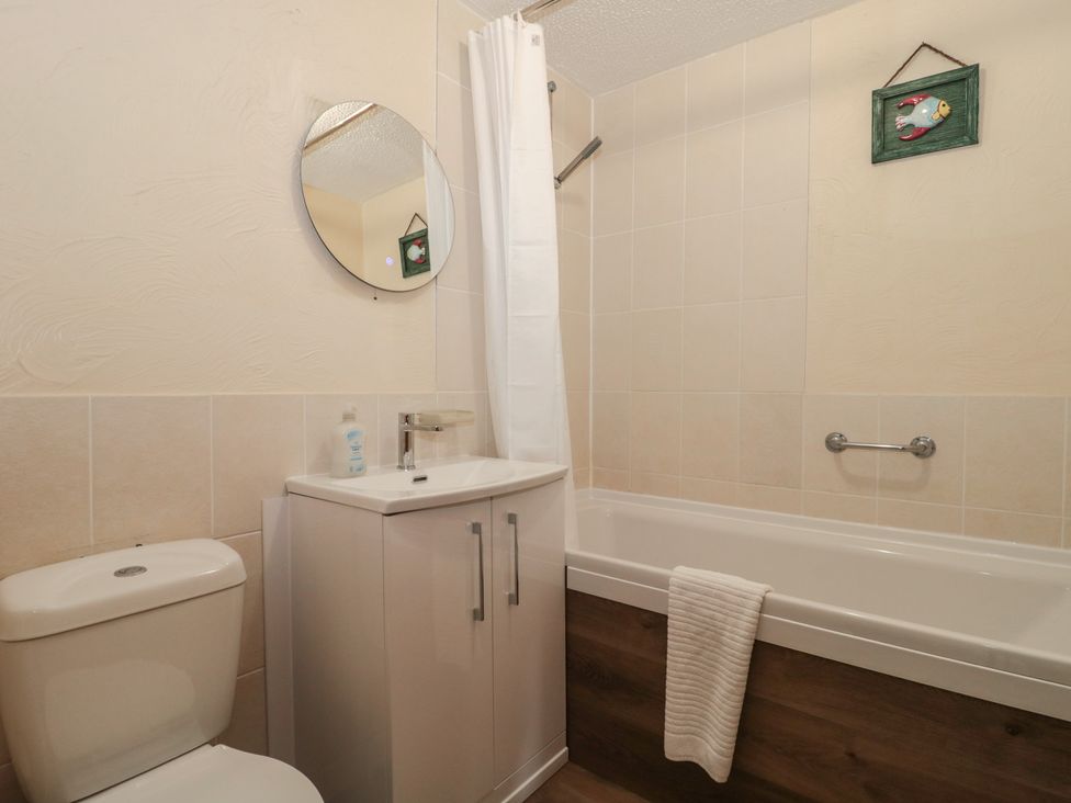 A bathroom with a bathtub, toilet, and sink at Oak Tree in Brean