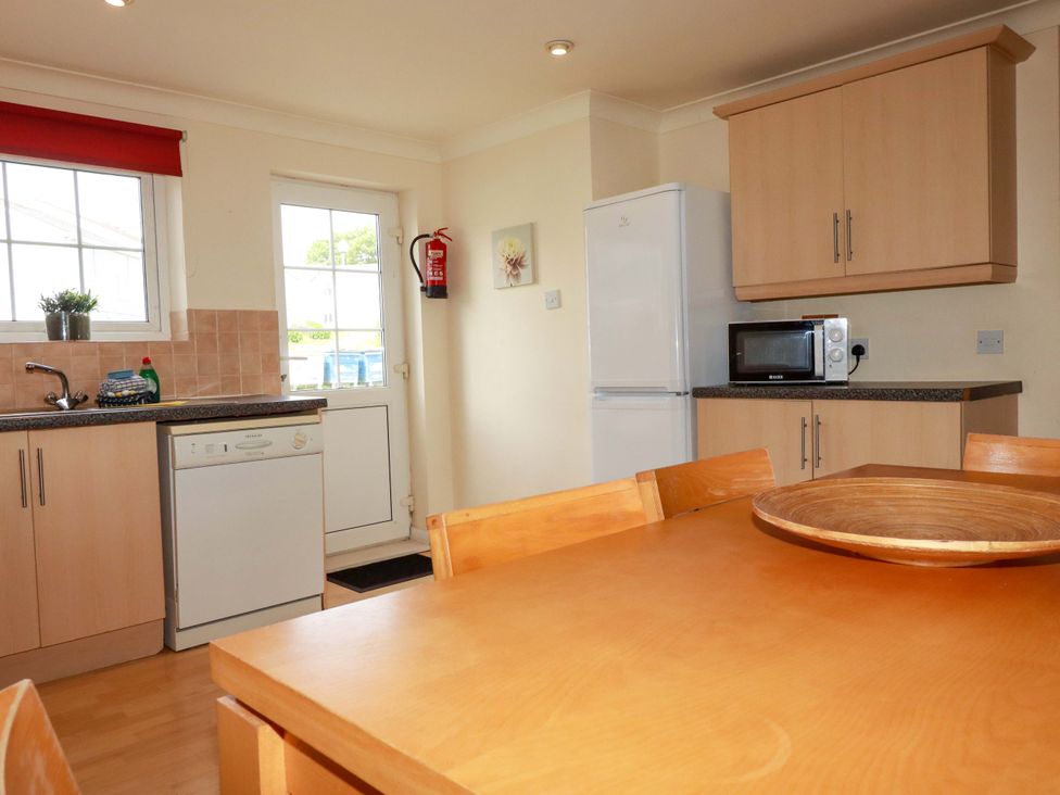 A kitchen with a table and appliances at 4 bed number 2 Atlantic Reach near St Columb Road