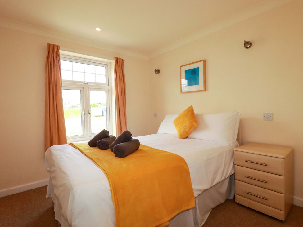A bedroom with a bed and nightstand at 4 bed number 2 in Atlantic Reach near St Columb Road