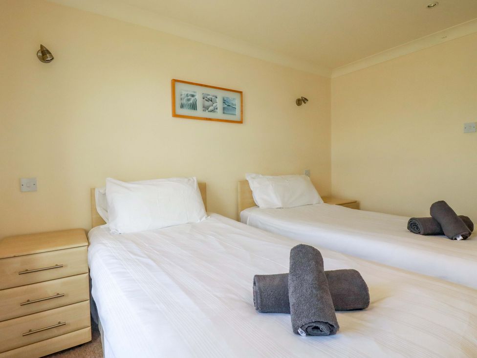 A bedroom with two beds and towels at 4 bed number 2 in Atlantic Reach near St Columb Road