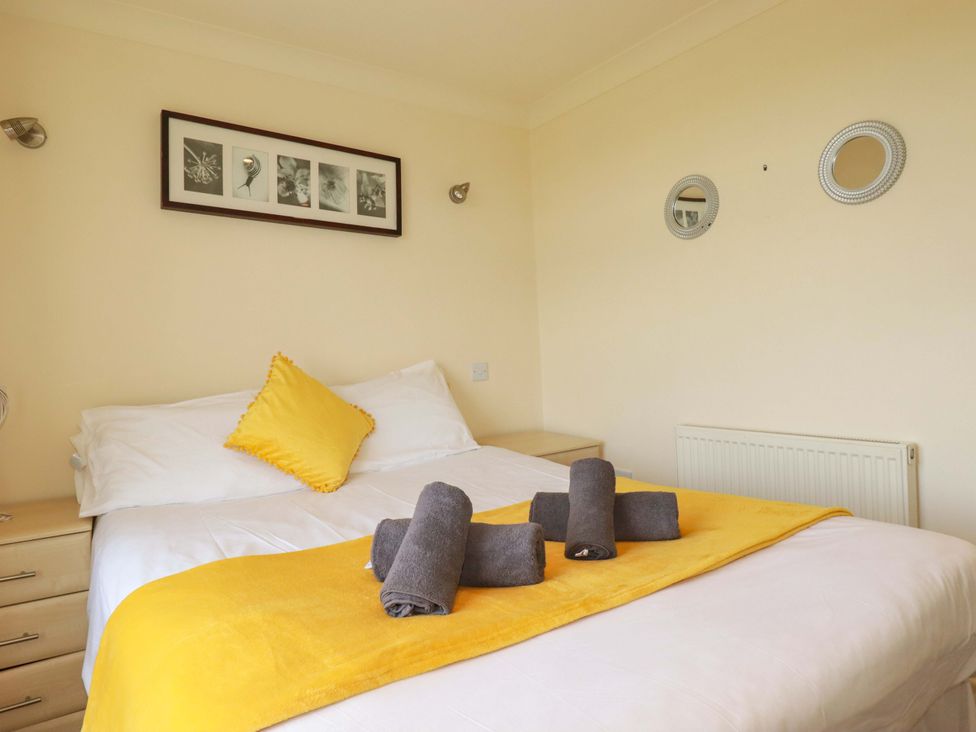 A bedroom with a bed and towels arranged on top at 4 bed number 2 Atlantic Reach near St Columb Road