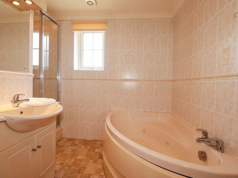 A bathroom with a bathtub, sink, and shower at 4 bed number 2 Atlantic Reach near St Columb Road