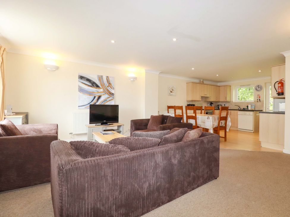 A living room with a TV and dining area at 4 bed number 20 Newquay