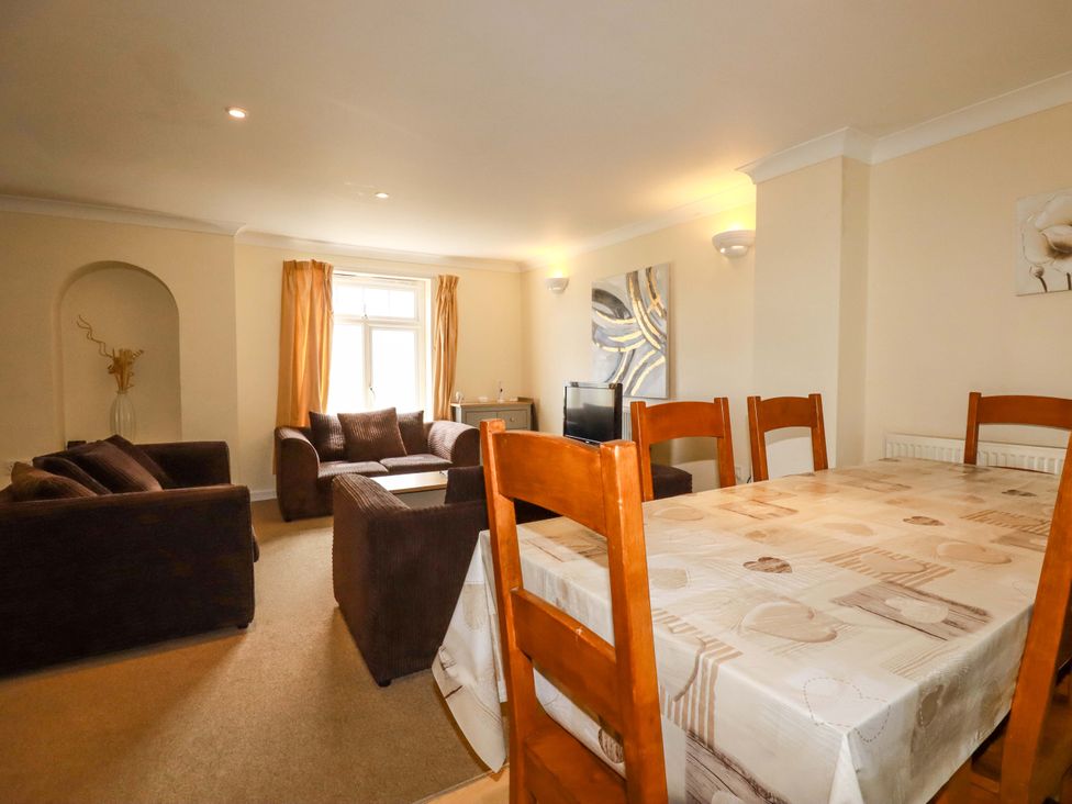 A living room with a dining table and sofa at 4 bed number 20 in Newquay
