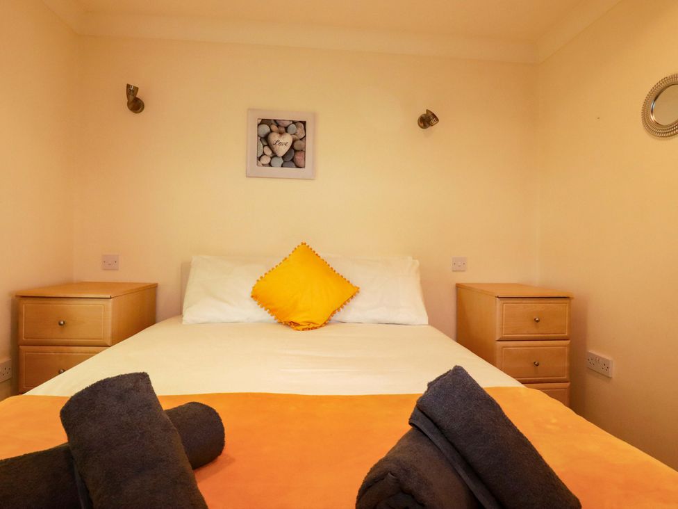 A bedroom with a bed and nightstands at 4 bed number 20 Newquay