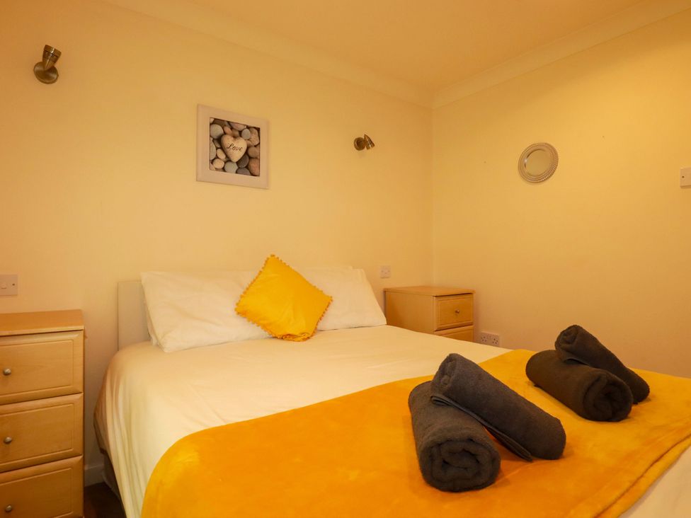 A bedroom with a bed and bedside table at 4 bed number 20 Newquay