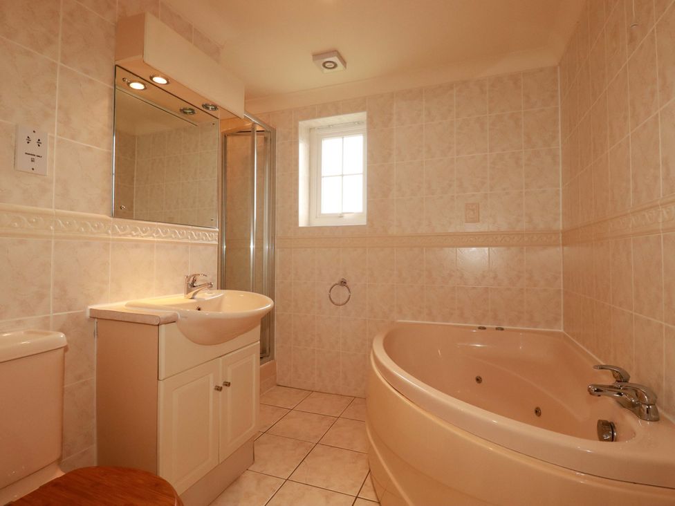 A bathroom with a sink, toilet, shower, and bathtub at 4 bed number 20 Newquay