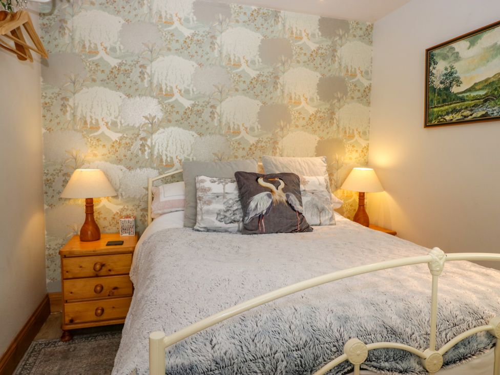 A bedroom with a bed and bedside table at La'al Yan in Branthwaite