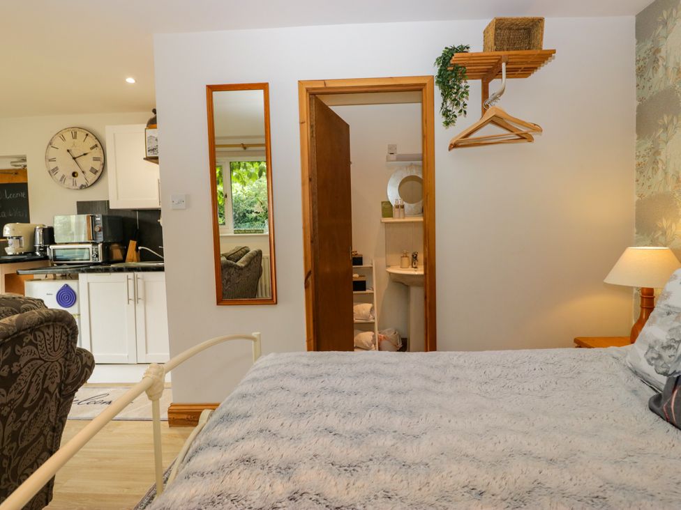 A bedroom with a bed and a door to a bathroom at La'al Yan in Branthwaite