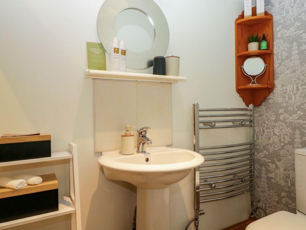 A bathroom with wash basin and mirror at La'al Yan in Branthwaite