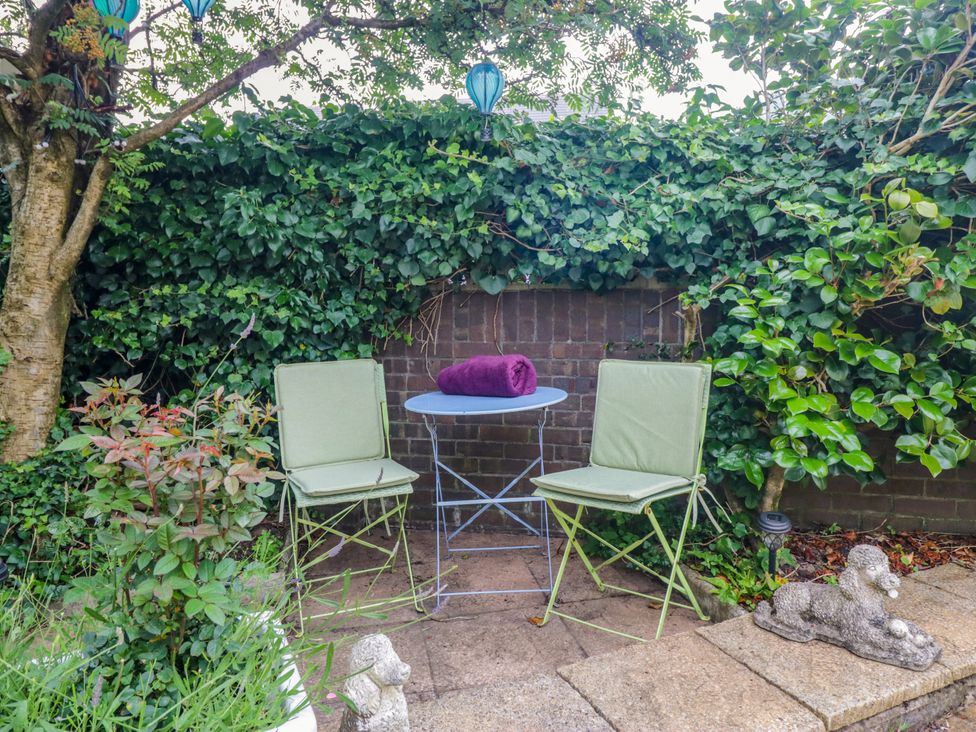 A garden with two chairs and a table at La'al Yan, Branthwaite