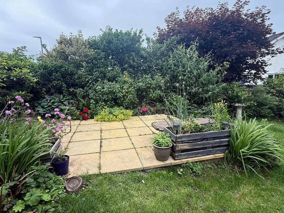 A garden with flowers and paving stones at La'al Yan in Branthwaite