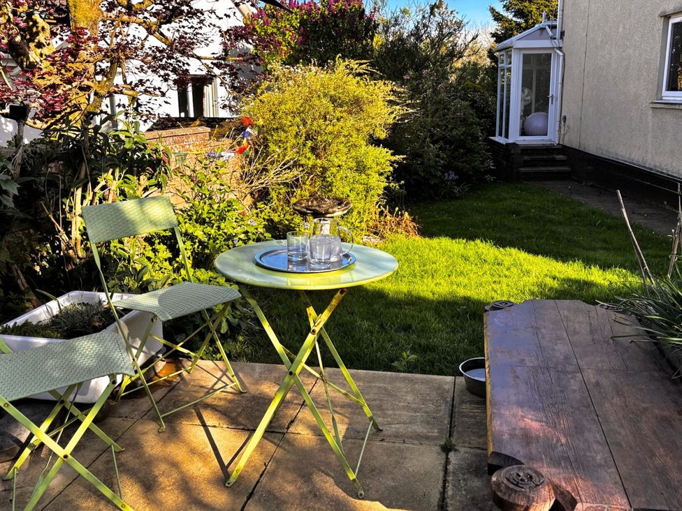 A garden with a table and chairs at La'al Yan in Branthwaite