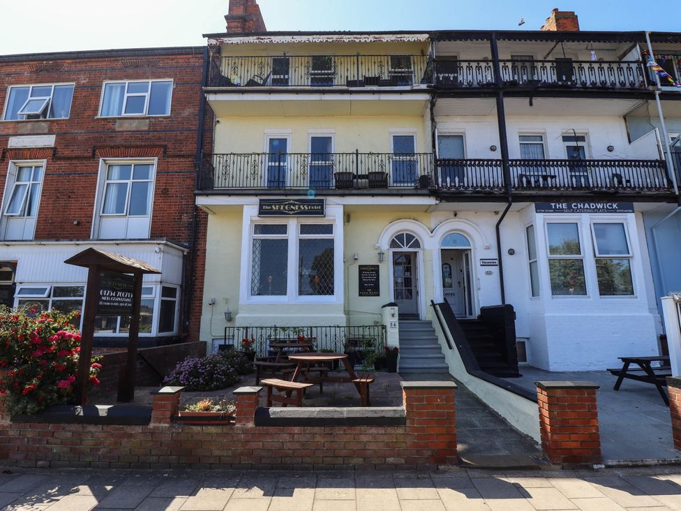 A building with balconies and outdoor seating at The Skegness Hotel in Skegness