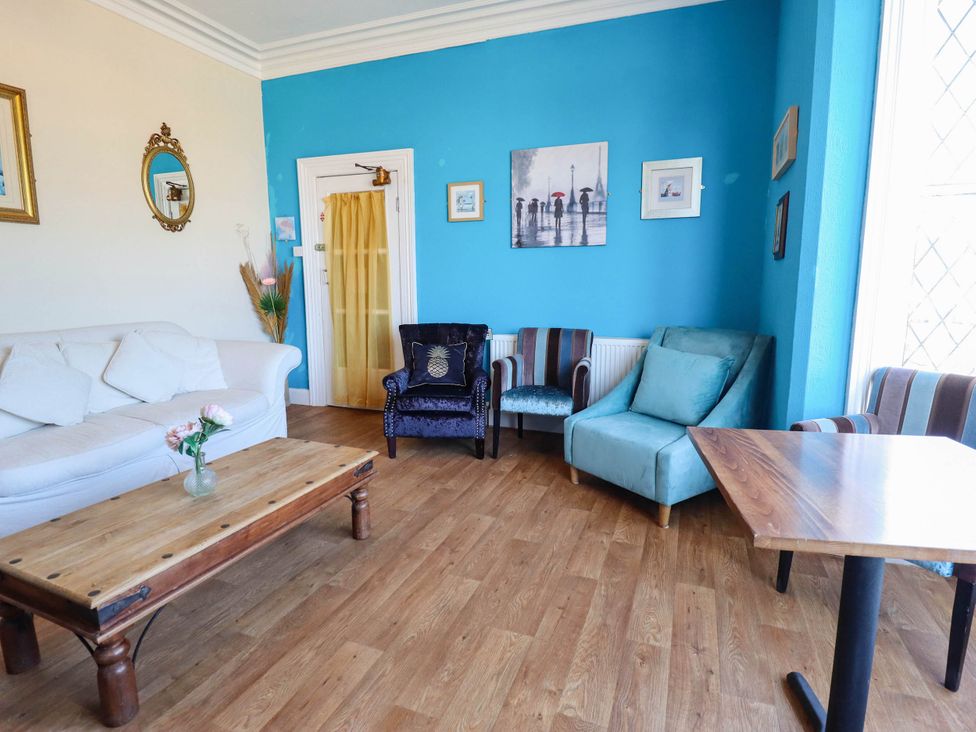 A living room with a sofa and table at The Skegness Hotel in Skegness