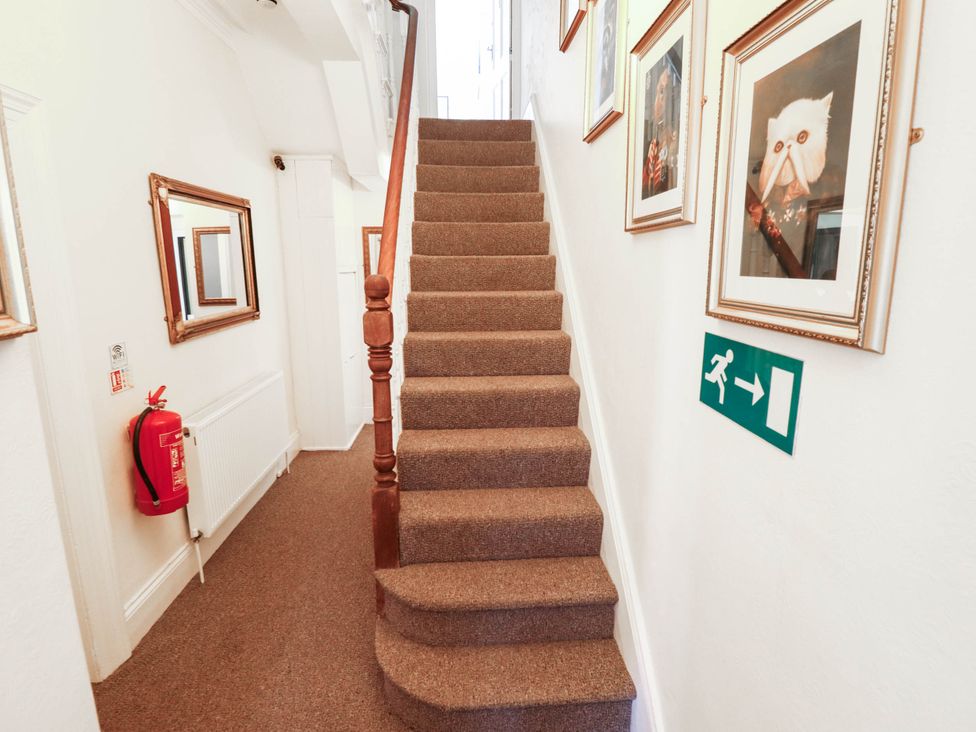 A hallway with stairs and artworks on the wall at The Skegness Hotel in Skegness