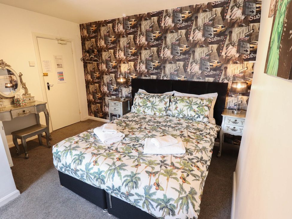 A bedroom with a bed and mirror at The Skegness Hotel in Skegness