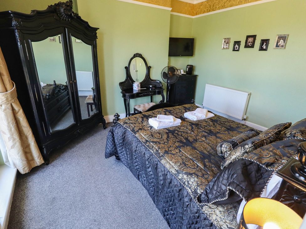 A bedroom with a bed and a wardrobe at The Skegness Hotel in Skegness